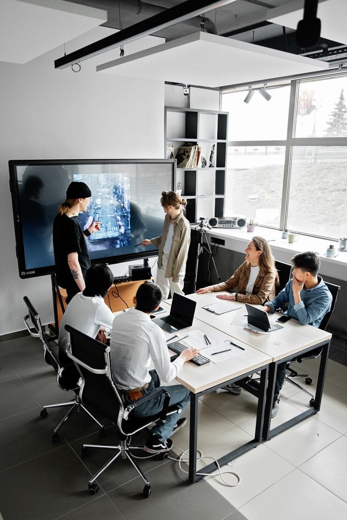 Home Modern office meeting with diverse team using technology for collaboration.