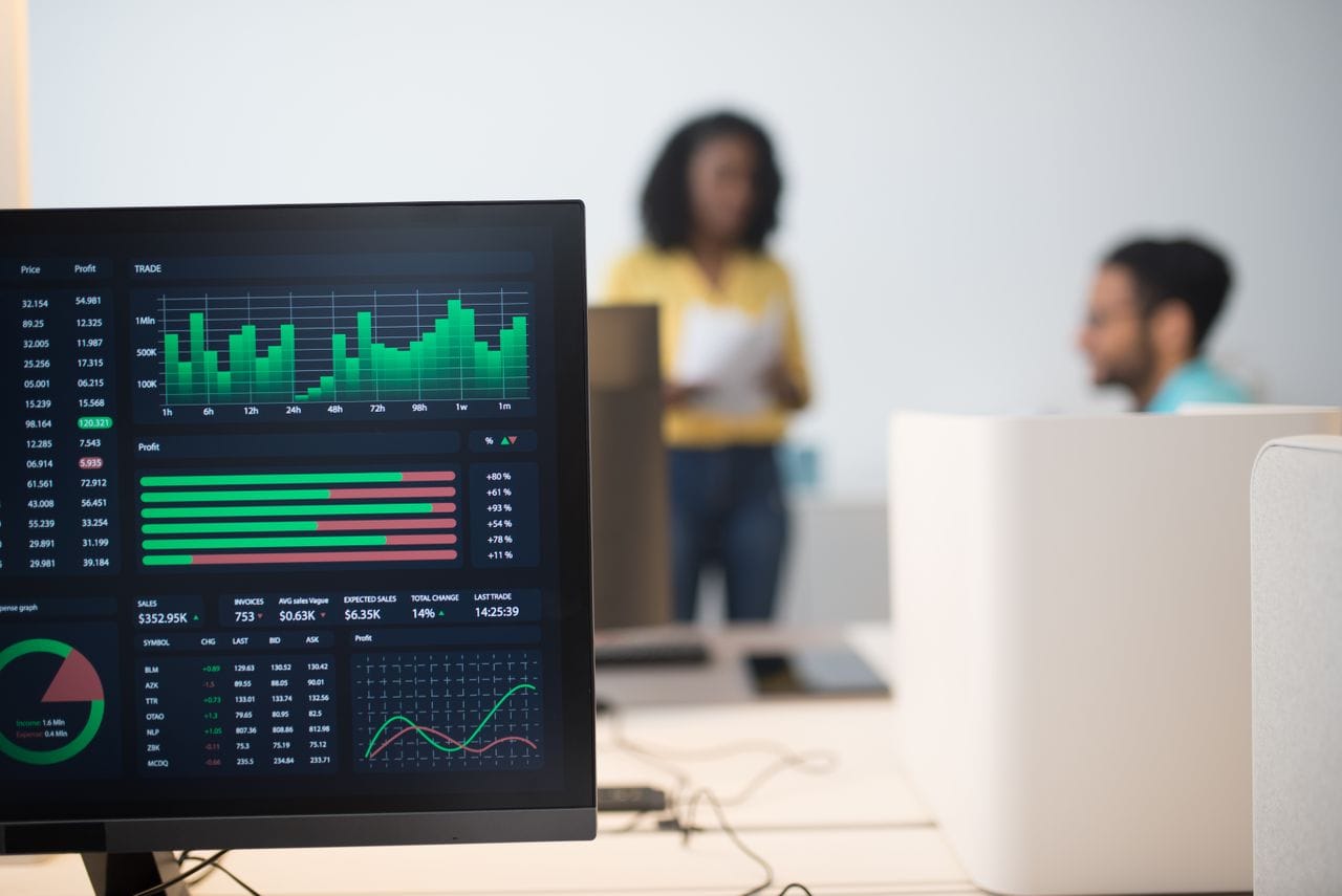Home Modern office with financial trading screens and a diverse team discussing strategies.